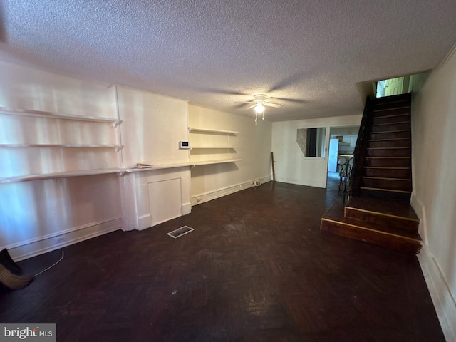 basement with ceiling fan and a textured ceiling