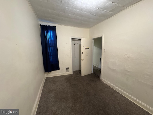 unfurnished room featuring dark carpet