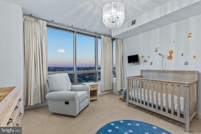 bedroom with a chandelier, a crib, and floor to ceiling windows