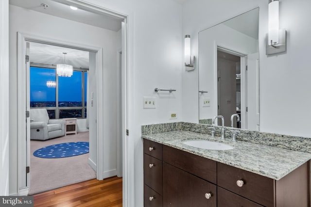 bathroom with an inviting chandelier, hardwood / wood-style flooring, and vanity