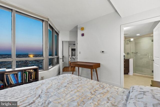 bedroom featuring a wall of windows and ensuite bath