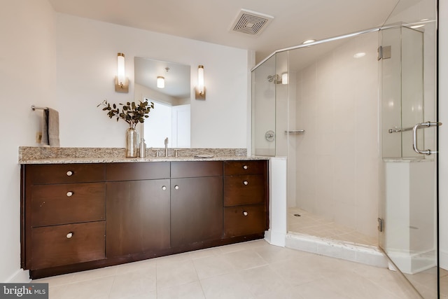 bathroom with tile patterned flooring, a shower with door, and vanity