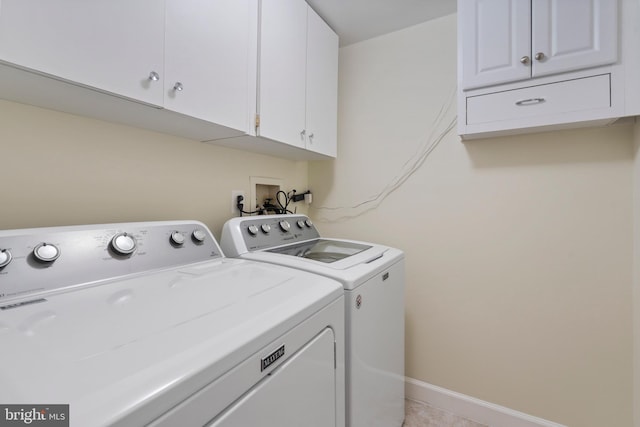 laundry area with washing machine and dryer and cabinets