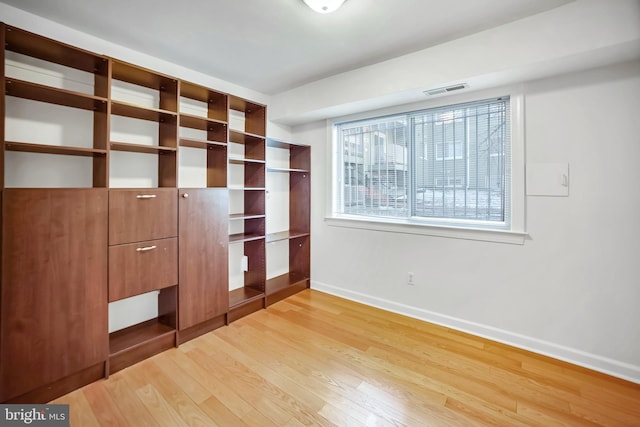 unfurnished bedroom with multiple windows and light wood-type flooring