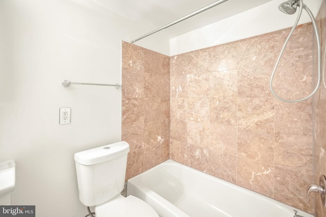 bathroom with toilet and tiled shower / bath