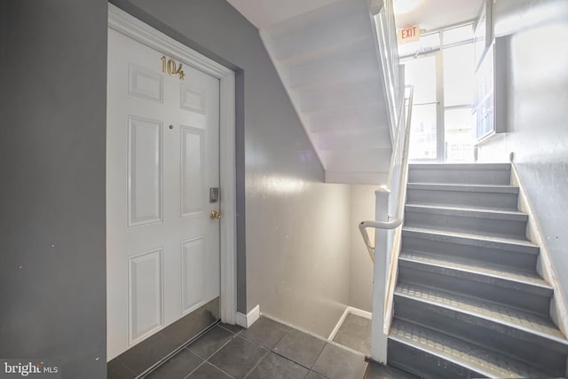 staircase with tile patterned floors and lofted ceiling