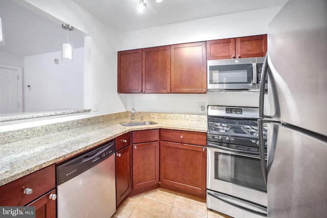 kitchen featuring light stone counters, sink, appliances with stainless steel finishes, and light tile patterned floors