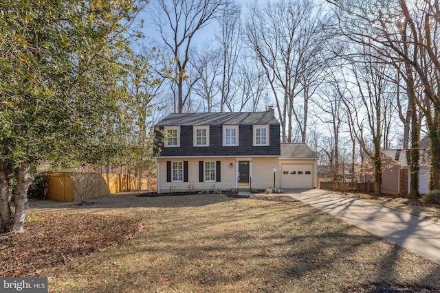 view of front of house with an attached garage, fence, a gambrel roof, driveway, and a front lawn