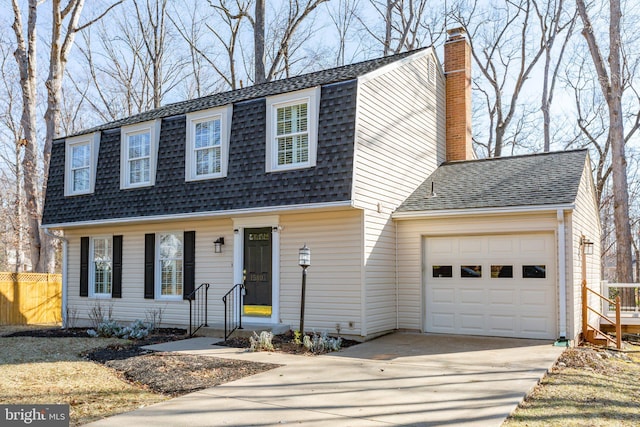 view of front of house featuring a chimney, a shingled roof, an attached garage, fence, and driveway