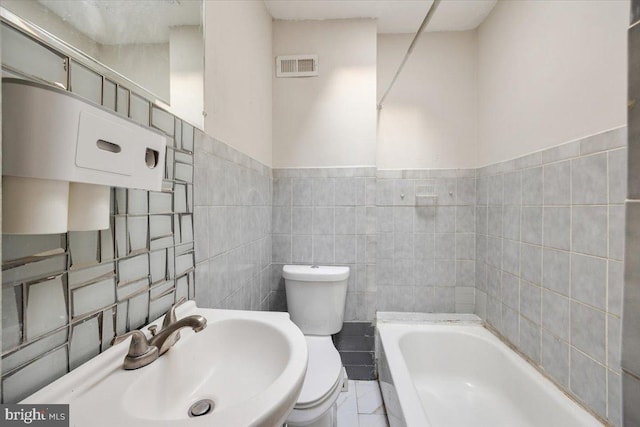 bathroom featuring sink, tile walls, a bathtub, and toilet