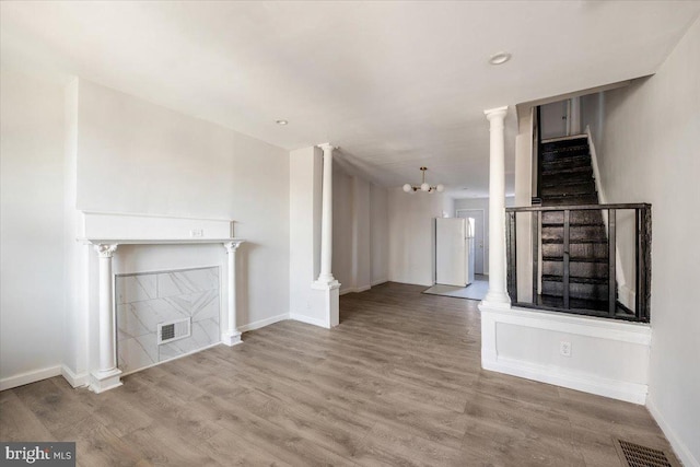 unfurnished living room with a chandelier and hardwood / wood-style flooring