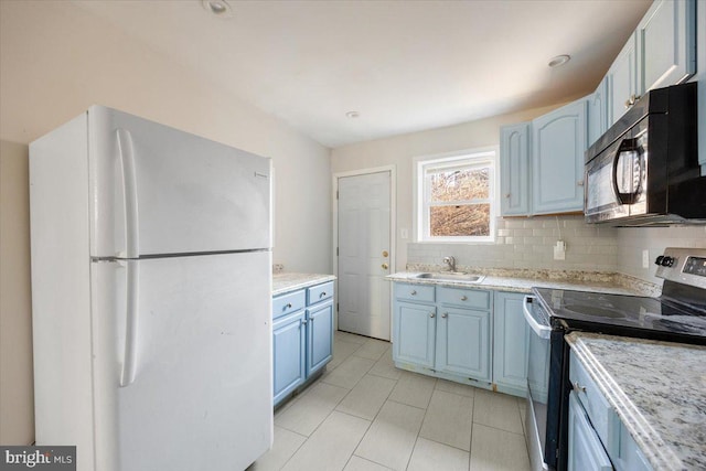 kitchen featuring white fridge, blue cabinetry, backsplash, sink, and stainless steel electric range oven