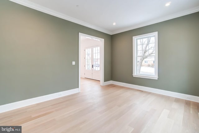 unfurnished room with light hardwood / wood-style floors, a wealth of natural light, and crown molding