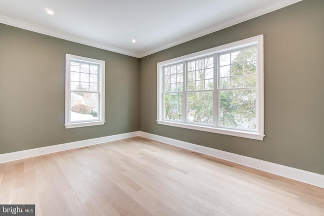 spare room featuring ornamental molding and light wood-type flooring