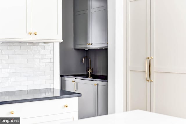 kitchen with sink, backsplash, and gray cabinetry