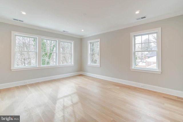 empty room featuring ornamental molding and light hardwood / wood-style flooring