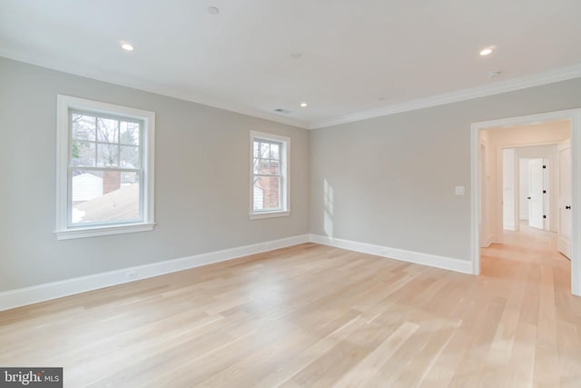 empty room with plenty of natural light, crown molding, and light hardwood / wood-style flooring