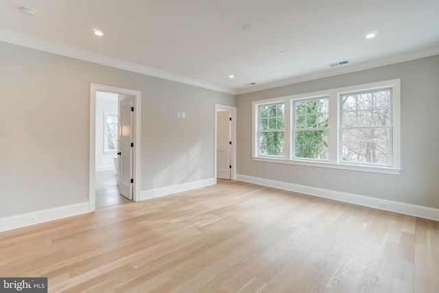 spare room with light hardwood / wood-style flooring and crown molding