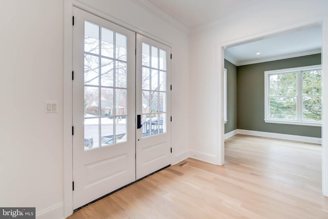 doorway featuring french doors, ornamental molding, and light hardwood / wood-style floors