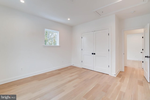 unfurnished bedroom with light wood-type flooring and a closet