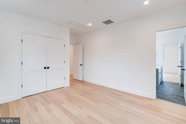 unfurnished bedroom featuring a closet and light hardwood / wood-style flooring