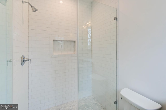 bathroom featuring an enclosed shower and toilet