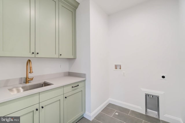 washroom with dark tile patterned flooring, cabinets, electric dryer hookup, washer hookup, and sink