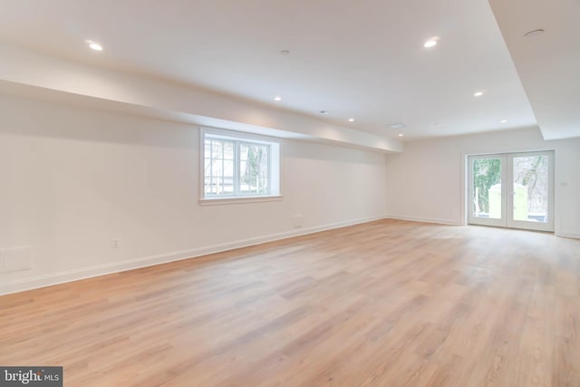 spare room featuring plenty of natural light, light hardwood / wood-style flooring, and french doors