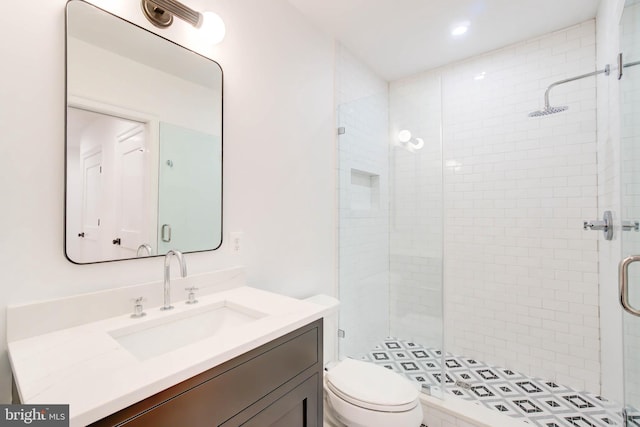 bathroom featuring toilet, vanity, and walk in shower