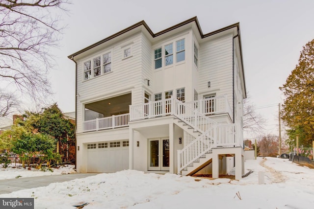 snow covered rear of property with a garage