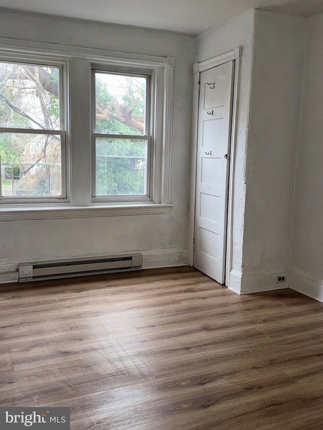 spare room featuring light hardwood / wood-style floors and a baseboard heating unit