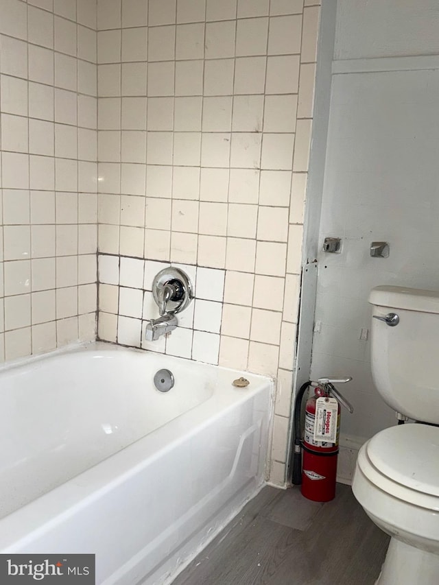 bathroom with toilet, shower / bath combination, and hardwood / wood-style floors