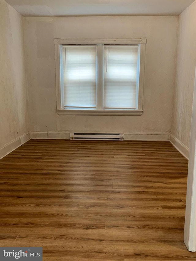 spare room featuring hardwood / wood-style flooring and a baseboard radiator