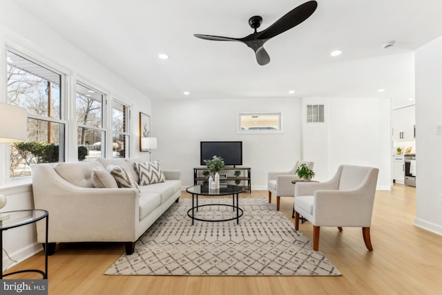 living room with ceiling fan and light wood-type flooring