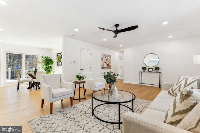 living room with ceiling fan and light wood-type flooring