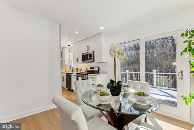 dining area featuring sink and light wood-type flooring