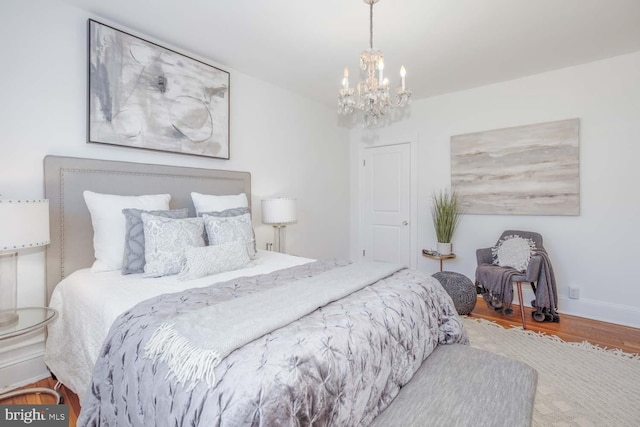 bedroom with hardwood / wood-style flooring and a chandelier