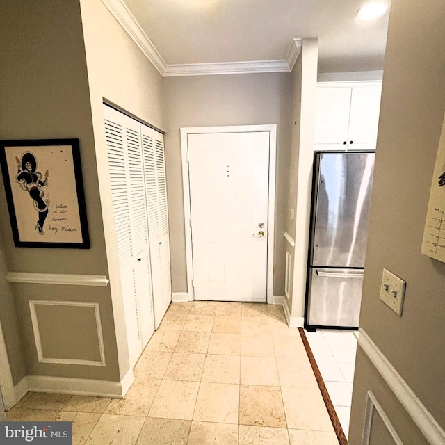 doorway to outside with light tile patterned flooring and ornamental molding