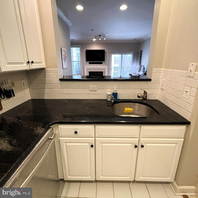 kitchen featuring dishwashing machine, sink, light tile patterned floors, white cabinetry, and ornamental molding