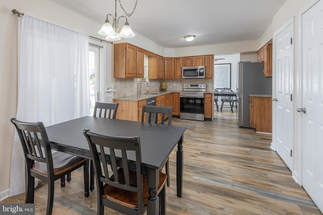 dining area featuring sink, dark hardwood / wood-style flooring, and a notable chandelier