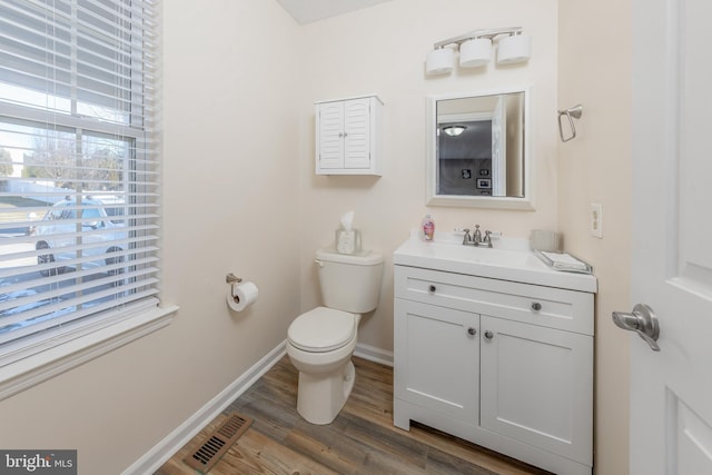 bathroom with toilet, hardwood / wood-style floors, and vanity