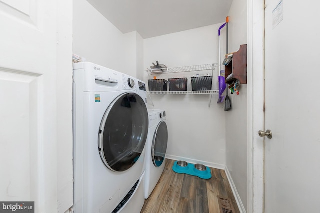 laundry area featuring washing machine and dryer and hardwood / wood-style floors