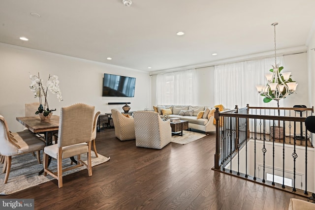 dining area featuring crown molding, dark hardwood / wood-style floors, and an inviting chandelier