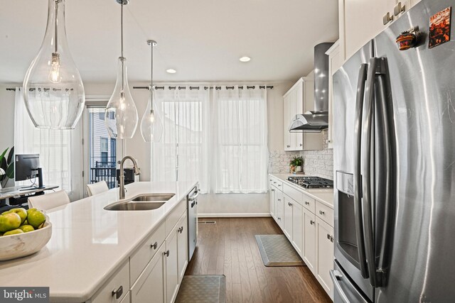 kitchen with sink, appliances with stainless steel finishes, white cabinetry, tasteful backsplash, and decorative light fixtures