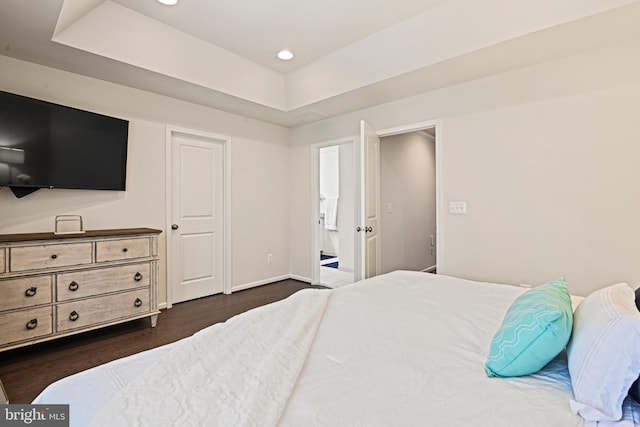 bedroom with dark wood-type flooring and a tray ceiling