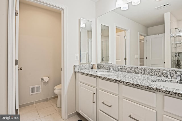 bathroom featuring vanity, tile patterned flooring, a shower with door, and toilet