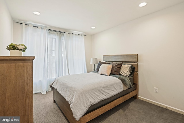 bedroom with multiple windows and dark carpet