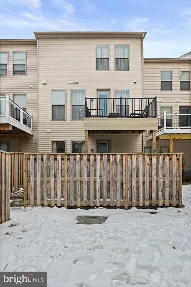 view of snow covered rear of property