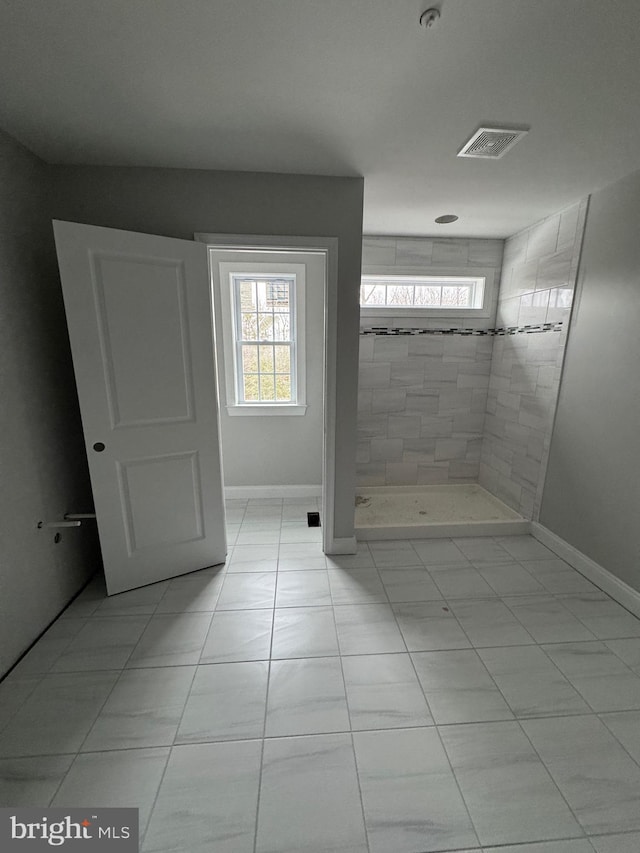 bathroom featuring a tile shower and tile patterned floors