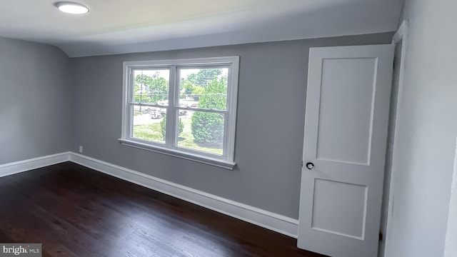 spare room with dark hardwood / wood-style floors and lofted ceiling